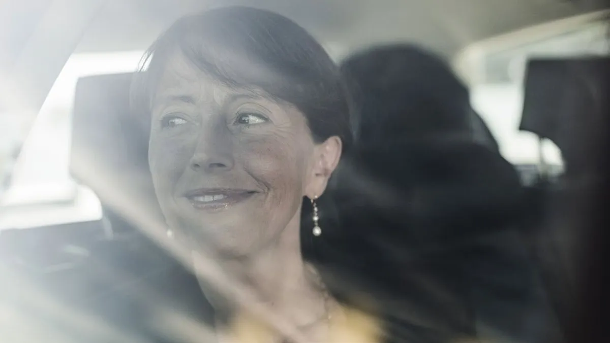 A smiling passenger in the back seat of a taxi (photo: Cabonline)