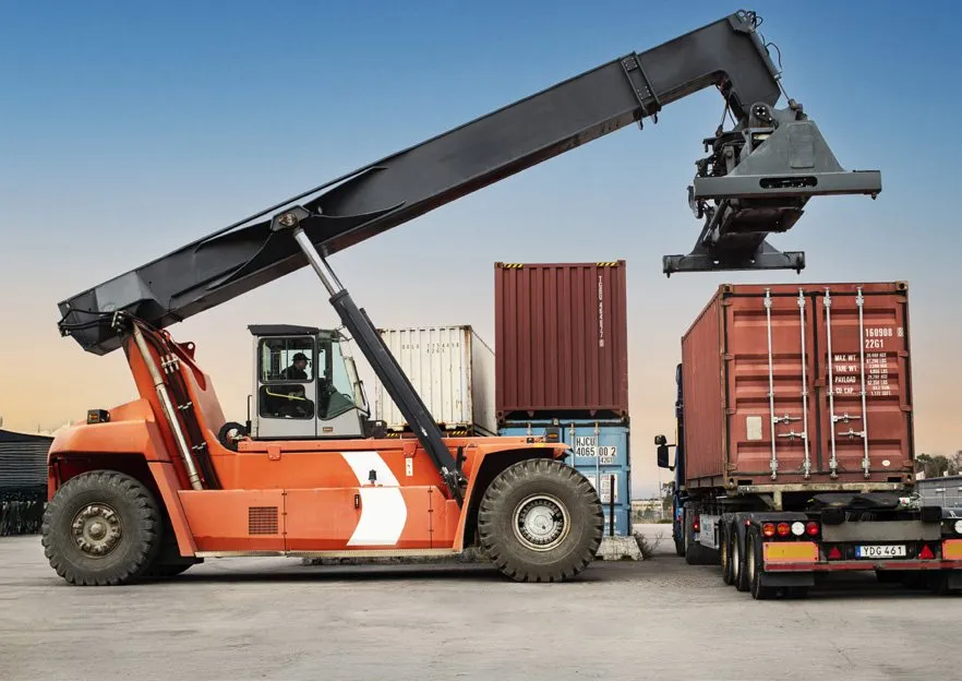 A reach stacker loading a container onto a truck, at a Storskogen company