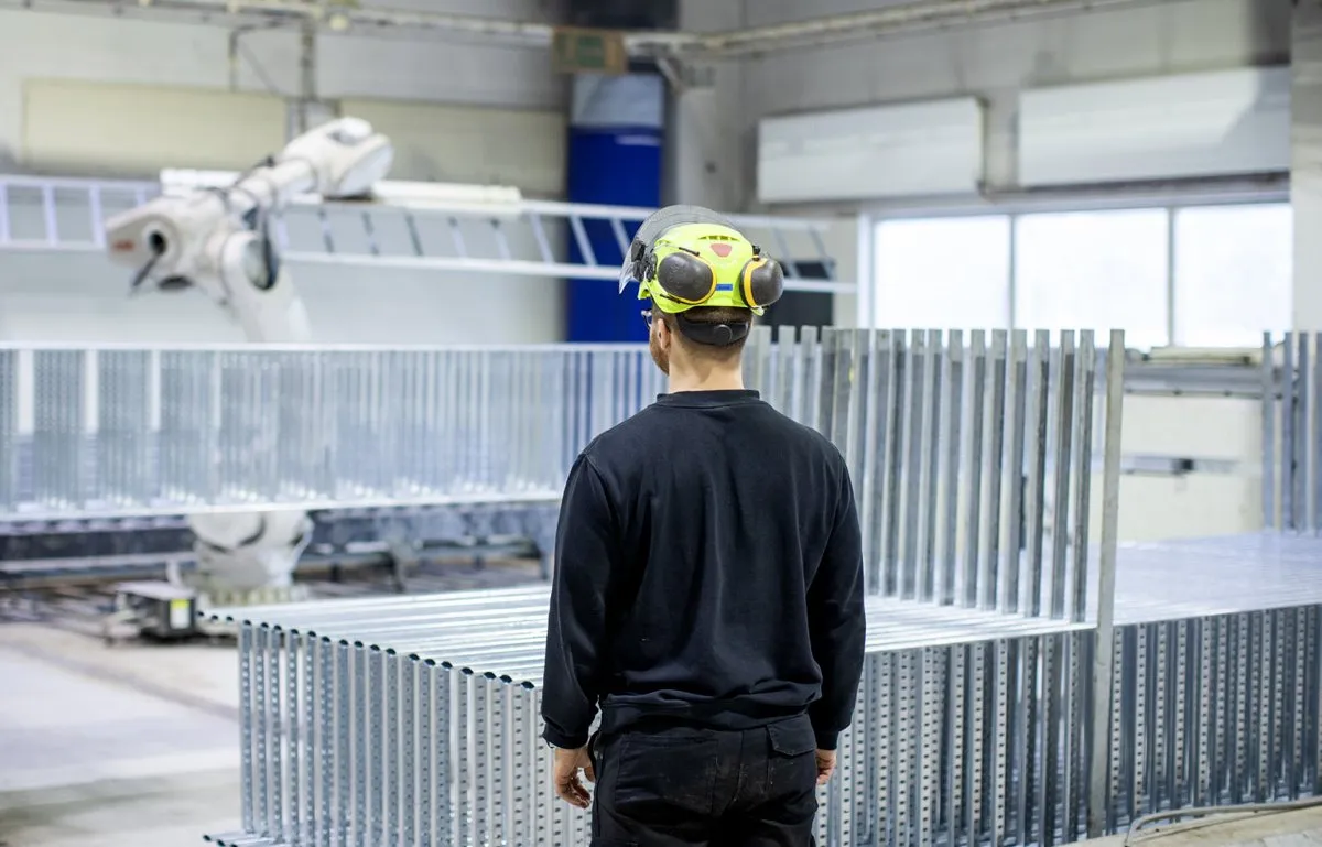 A worker in a hard hat in a metal workshop at a Storskogen company