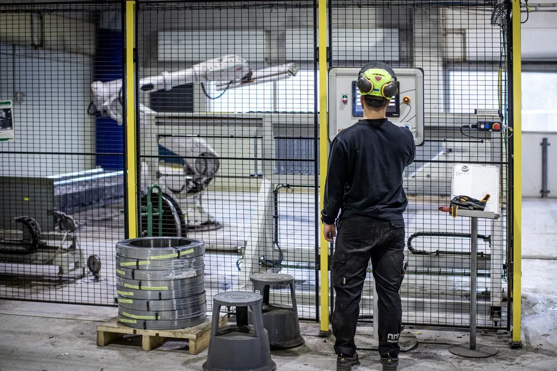 A machine operator standing at an industrial press
